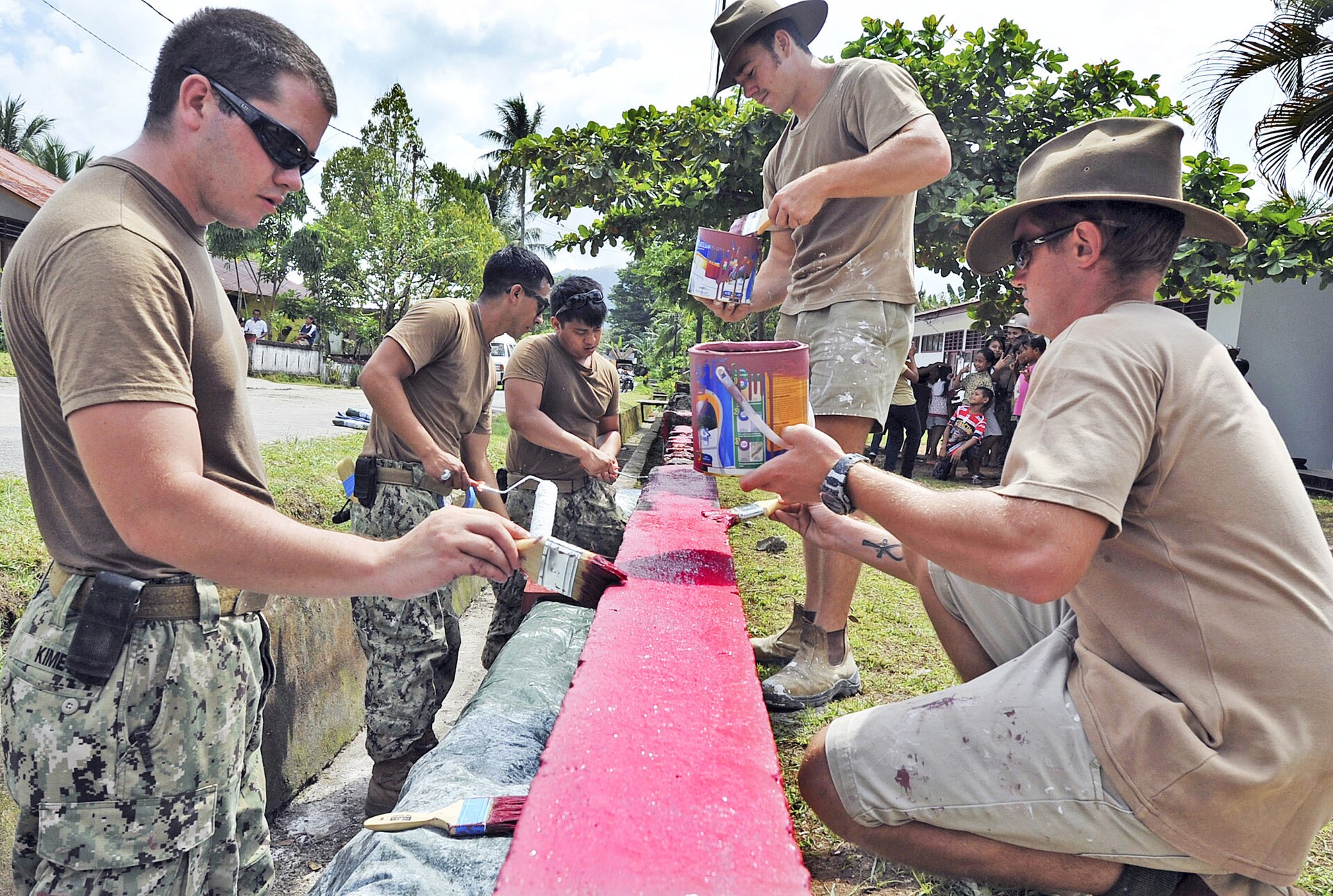 TALAUD, Indonesia (June 9, 2012) A joint engineering civil action program team made up of personnel from Naval Mobile Construction Battalion (NMCB) 40, the Australian 6th Engineer Support Regiment and the Australian 21st Construction Squadron, paint a wall outside the Beo Health Center in Talaud during a Pacific Partnership 2012 community service project. The team includes Construction Mechanic Christopher Kime, left, and Sappers Brent Wetten and Alexander McDowell. Pacific Partnership is an annual U.S. Pacific Fleet humanitarian and civic assistance mission now in its seventh year that brings together U.S. military personnel, host and partner nations, non-government organizations and international agencies to build stronger relationships and develop disaster response capabilities throughout the Asia-Pacific region. (U.S. Navy photo by Mass Communication Specialist 2ND Class Roadell Hickman/Released) 120609-N-7441-001 Join the conversation www.facebook.com/USNavy www.twitter.com/USNavy navylive.dodlive.mil